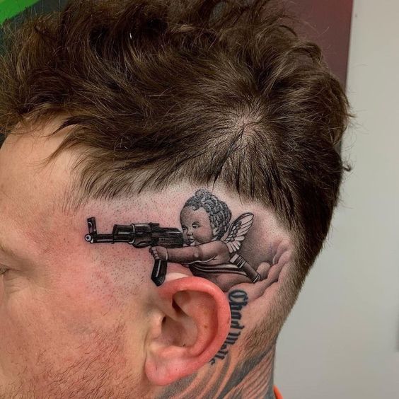 Baby with gun Behind the ear tattoo