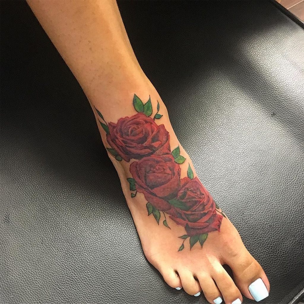 Red and green inked Rose Tattoo on foot
