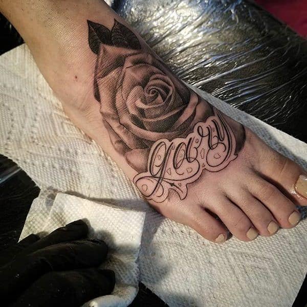 A big black inked Rose Tattoo on foot design