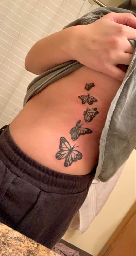 black simple butterfly side belly tattoo for girls