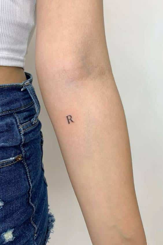 dainty initial tattoo , R tattoo , arm tat